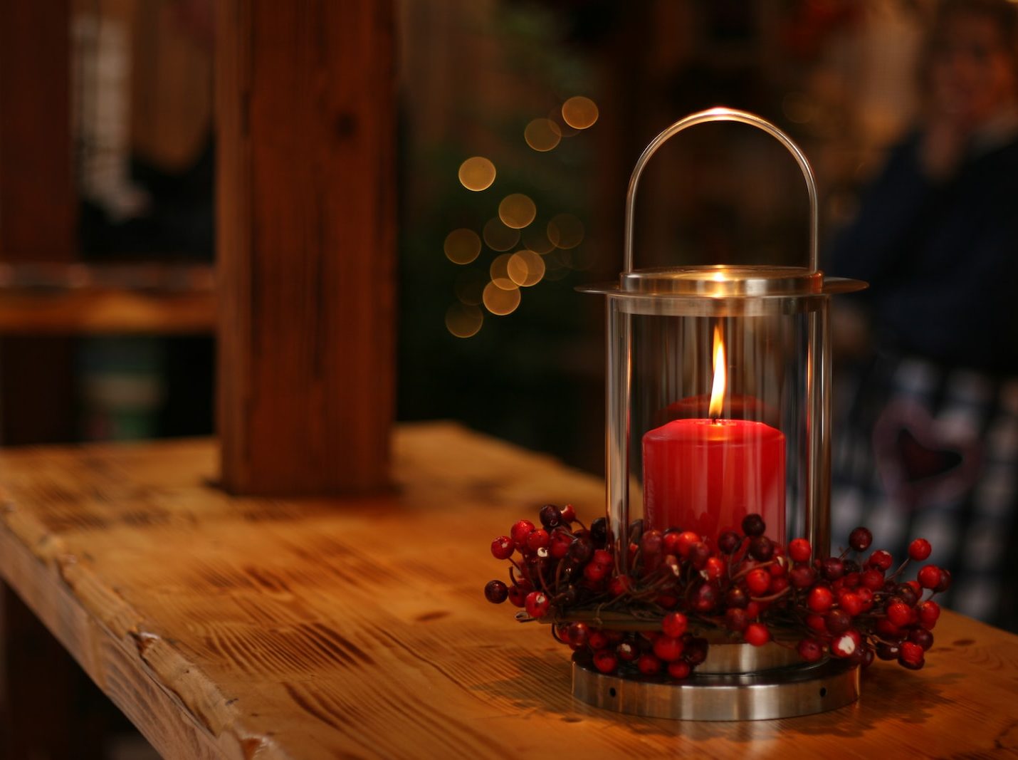 red lighted candle on brown wooden frame