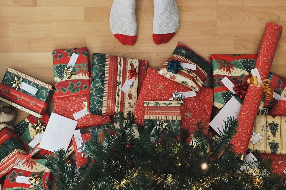 Photo by Andrew Neel person standing beside christmas tree