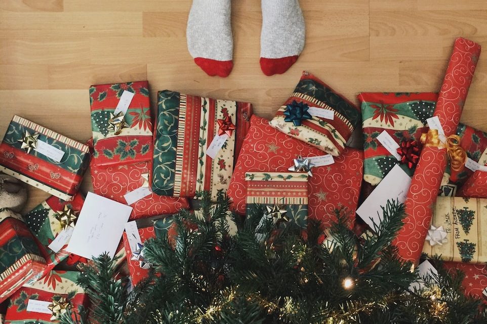 person standing beside christmas tree